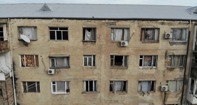 Gence’de füze saldırısı sonucu camları kırılan savaşzedeler kırılan camlarını naylon ve kilimle örttü