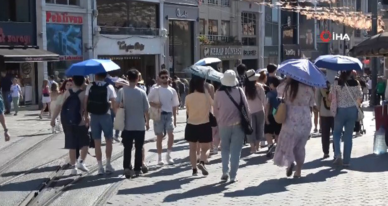 İSTANBUL’DA SICAK HAVA BUNALTIRKEN, TURİSTLER TAKSİM’DE ŞEMSİYE İLE GEZDİ