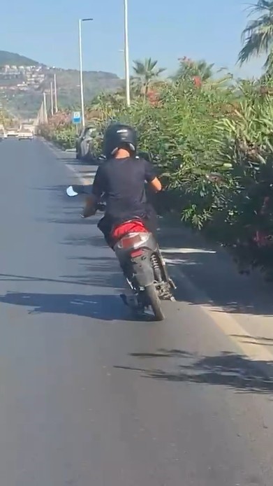 ALANYA’DA MOTOSİKLET ÜZERİNDE AYAKTA İLERLEYEN SÜRÜCÜNÜN TEHLİKELİ YOLCULUĞU KAMERADA