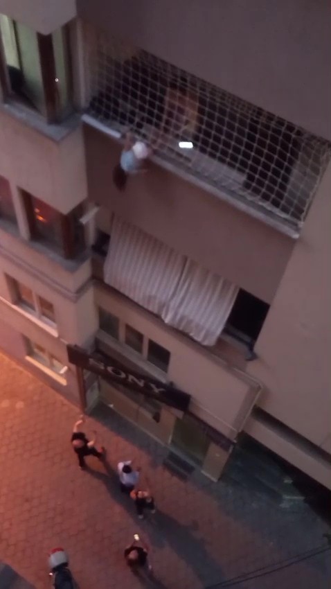 BALKON FİLESİNDE ASILI KALAN ÇOCUĞUNU DÜŞMESİN DİYE DAKİKALARCA TUTTU